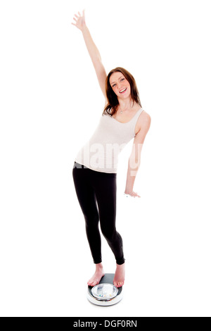 a girl on a weighing scale, celebrating her success of loosing weight Stock Photo