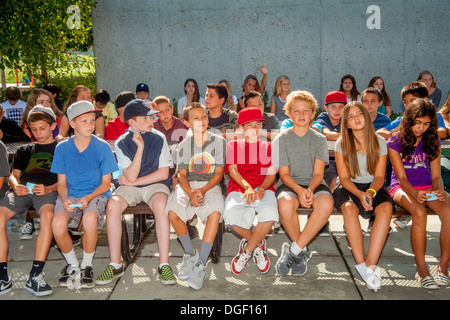 Middle school students listen to an outdoor lecture on appropriate campus behavior at the beginning of term. Stock Photo