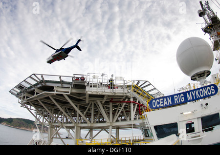 Helicopter landing/departing from an offshore oil drilling ship, Ocean RIG MIKONOS, anchored in front Rio de Janeiro, Brazil. Stock Photo