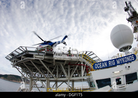 Helicopter landing/departing from an offshore oil drilling ship, Ocean RIG MIKONOS, anchored in front Rio de Janeiro, Brazil. Stock Photo