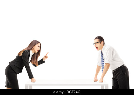 Angry businessman yelling at businesswoman who is threatening Stock Photo