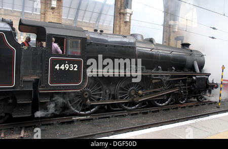 London, UK. 20th Oct, 2013. 'The Imitation Game' - a new film starring Benedict Cumberbatch, Keira Knightley, Henry Cavill and Mark Strong - is filmed at Kings Cross Raliway Sation in London with steam trains next to current day passenger trains. Scenes with children dressed in wartime clothes and others dressed as soldiers were seen as regular passengers arrived at the busy London concourse on Sunday October 20th 2013  Photo by Keith Mayhew/Alamy Live News Stock Photo