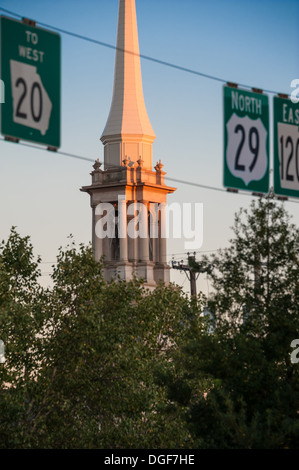 Sunlit steeple seen between highway signs in downtown Lawrenceville, Georgia, near Atlanta. (USA) Stock Photo