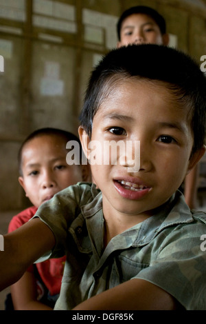 Three young boys are gathered in their classroom at the Ban Bumlao primary school in Ban Bumlao, Luang Prabang Province, Laos. Stock Photo