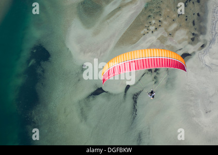 Paraglider over the Maggia river delta with naturally formed water and rocks terrain, Locarno, Kanton Tessin, Switzerland Stock Photo