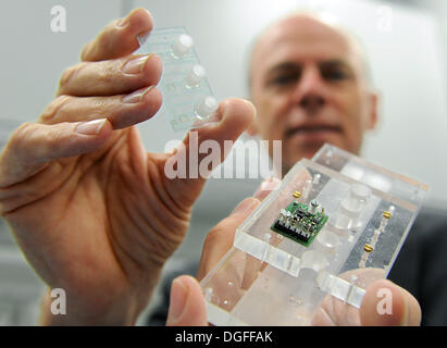 Bremen, Germany. 04th Oct, 2013. Michael Vellekoop presents a chip and its control electronics, with which the nutrient content in soils can be determined, in a laboratory at the University of Bremen, Germany, 04 October 2013. Vellekoop is one of two directors of the Institute for Microsensors, -actuators and -systems (IMSAS) at the University of Bremen. His team and the Technical University of Vienna have developed the chip in the Eureopean project 'Optifert' to optimize fertilization in agriculture. Photo: Ingo Wagner/dpa/Alamy Live News Stock Photo