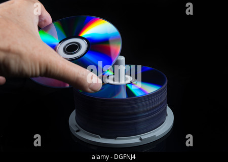 hand picking a dvd from a stack, cd, blu ray, Stock Photo