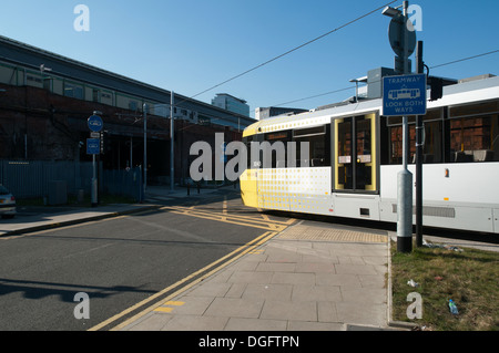 A Metrolink tram crossing Sheffield Street, near Piccadilly Station, Manchester, England, UK Stock Photo