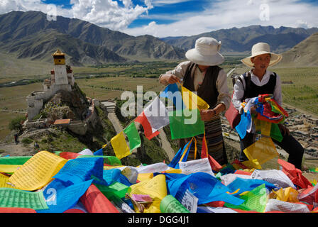 Tibetan women with prayer flags, view of Yumbulagang Fortress and Yarlung Valley, Tsetang, Tibet, China, Asia Stock Photo