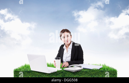 a woman working on a desk of grass Stock Photo