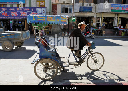 Rickshaw driver in the historic town centre of Shigatse, Tibet, China, Asia Stock Photo