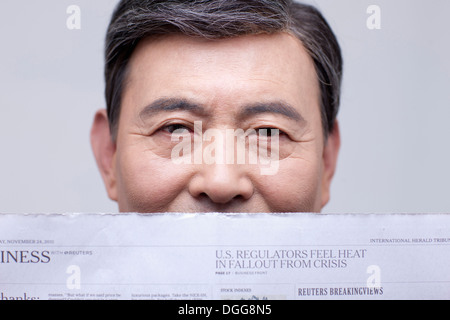 an old man reading a news paper Stock Photo