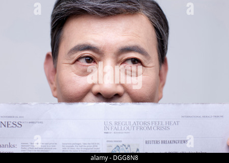 an old man reading a news paper Stock Photo