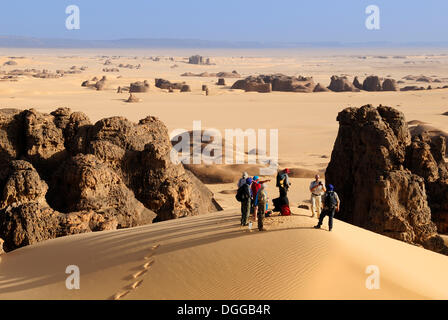 Group of tourists, hikers in the sandstone rock formation of Tin Akachaker, Tassili du Hoggar, Wilaya Tamanrasset, Algeria Stock Photo