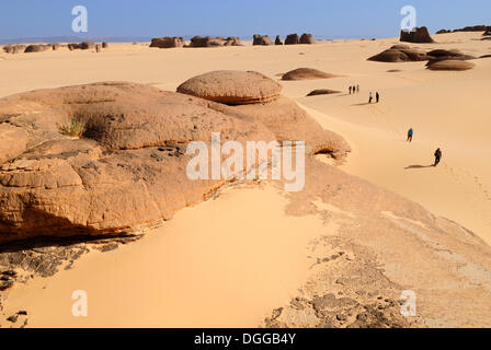 Group of tourists, hikers in the sandstone rock formation of Tin Akachaker, Tassili du Hoggar, Wilaya Tamanrasset, Algeria Stock Photo