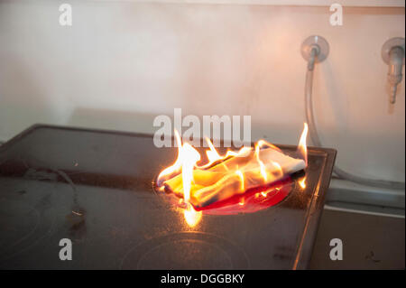 Towel lying on a switched on hot plate demonstrating fire causes such as kitchen fires, Stuttgart, Baden-Wuerttemberg Stock Photo