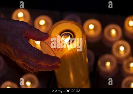 Hand of a devotee lightening a candle for offering inside the Frauenkirche church, Dresden, Saxony Stock Photo