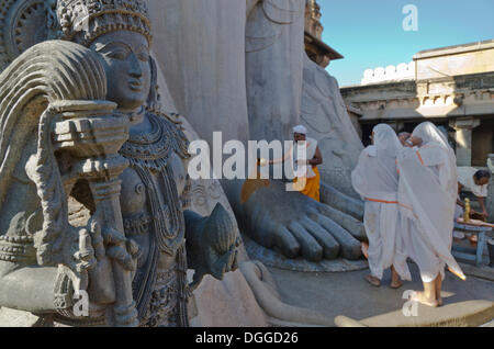 Jain pilgrims doing a special pooja in front of the gigantic statue to receive the blessings of Bahubali by the local priests Stock Photo