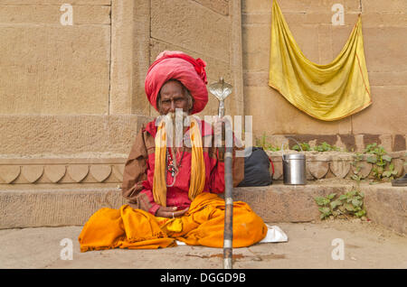 Sadhu, holy man, sitting at one of the ghats of the historic city of Varanasi, India, Asia Stock Photo