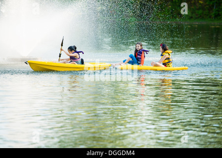 Girls canoeing on lake Stock Photo