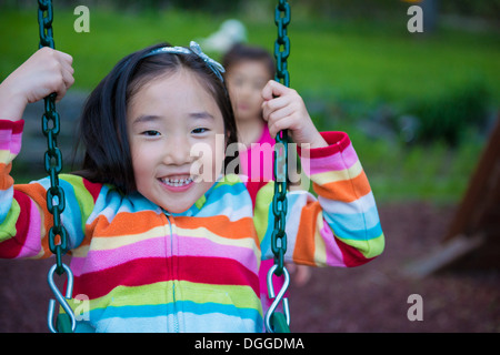 Girl wearing striped top on swing Stock Photo