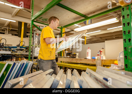 Worker carrying frame in screen printing workshop Stock Photo