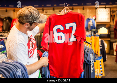 Man holding up t-shirt in store Stock Photo