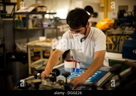 Worker with safety mask in screen printing workshop Stock Photo