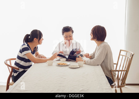 Three generation family looking at photograph album Stock Photo