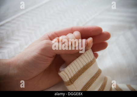 Baby boy holding mother's hand, close up Stock Photo