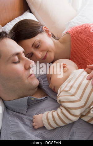 Parents resting together with baby boy Stock Photo