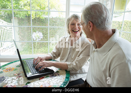 Senior couple using laptop in conservatory Stock Photo