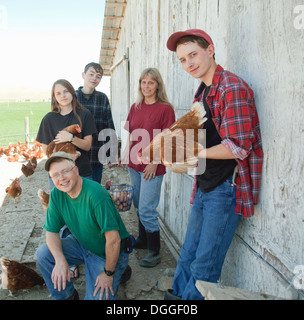 Farming family holding chickens, portrait Stock Photo