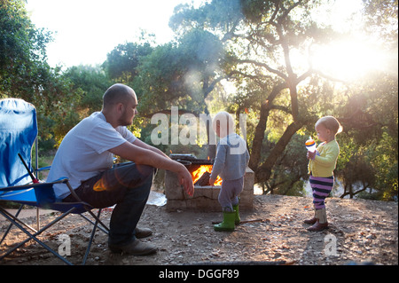 Toddler twins on camping site with father Stock Photo