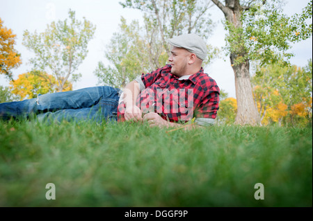 Young man lying on grass in park Stock Photo