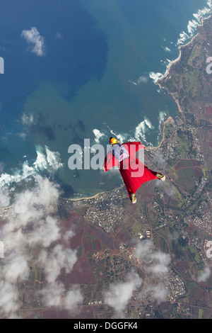 Woman in wingsuit flying above Honolulu, Hawaii Stock Photo