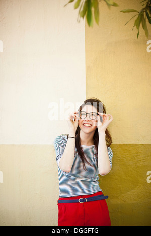 Portrait of young woman in front of color divided wall Stock Photo