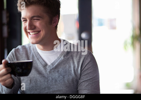 Portrait of young man in cafe holding cup Stock Photo