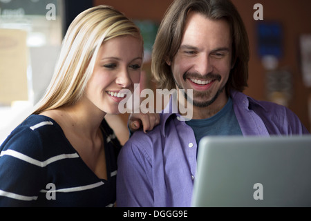 Teenage girl and mentor looking at computer in cafe Stock Photo