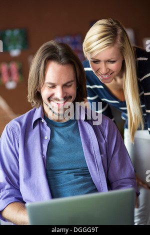 Teenage girl and mentor using at computer in cafe Stock Photo