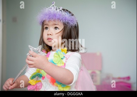 Girl in fairy costume holding magic wand Stock Photo