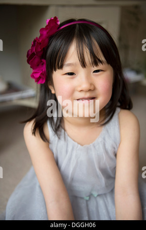 Portrait of girl with flower in hair, smiling Stock Photo