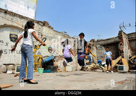 Children playing with a skipping rope in the ruins of a house, indigenous community in a slum, Mexico City, Ciudad de Mexico Stock Photo