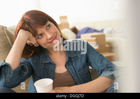 Woman taking a break whilst moving house Stock Photo