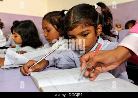 Teacher correcting the work of a schoolgirl in a school of the Christian community in Lahore, Punjab, Pakistan, Asia Stock Photo