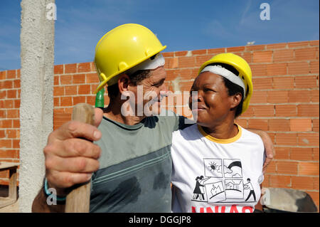 Couple in love, man and woman, 50 years, looking at each other, they are working together on a building site of the "Esperanca" Stock Photo