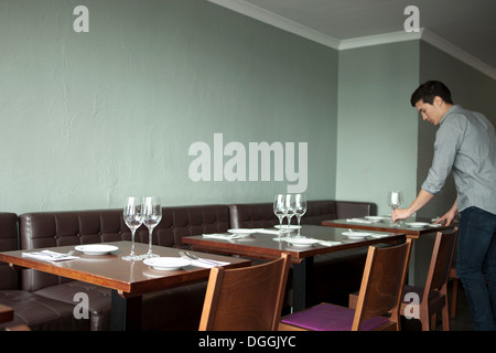 Waiter setting table in restaurant Stock Photo