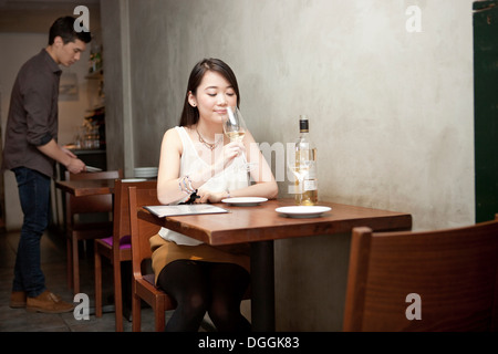 Young woman holding wine glass in restaurant Stock Photo