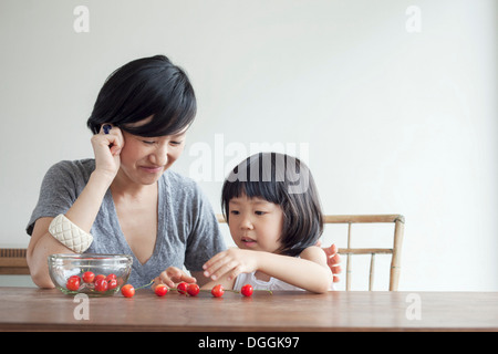 Mother and daughter counting cherries Stock Photo
