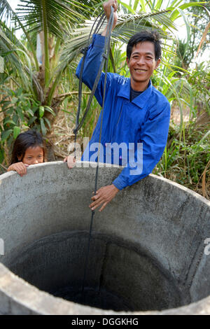 Man fetching water from a well, Trapang Village, Bathi District, Takéo Province, Cambodia Stock Photo